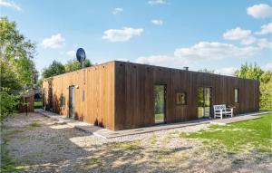 a wooden house with a bench in a yard at Beautiful Home In Sjællands Odde in Yderby
