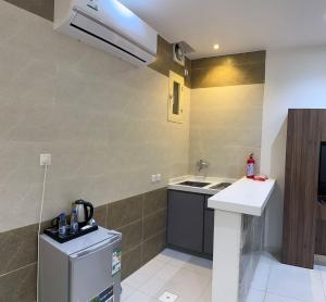 a small kitchen with a sink and a refrigerator at فندق نواهل السيل in As Sayl aş Şaghīr