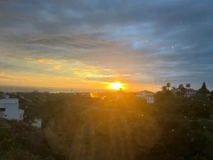 a sunset over a city with the sun setting at Marbella Boutique Art suites in Marbella