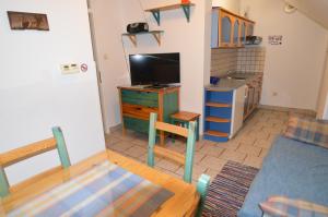 a kitchen with a table and a tv in a room at Apartments Cokla in Zreče