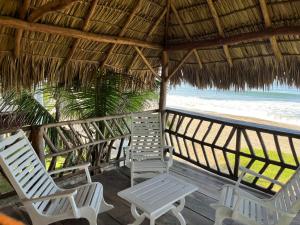 two chairs and a table on a deck with the beach at Sandollar in León