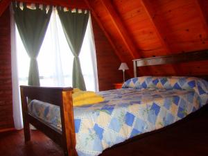 a bedroom with a bed in a room with windows at Cabañas Mirador del Cerro in Sierra de la Ventana +54 photos