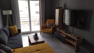 a living room with a couch and a television at Modern & Charming Mitilini in Mytilene