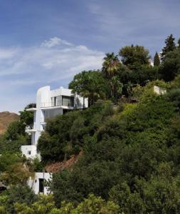 a white house on top of a hill with trees at Marbella Boutique Art suites in Marbella