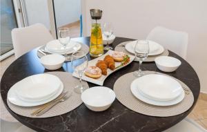 a black table with white plates and wine glasses at 1 Bedroom Awesome Apartment In Klek in Klek
