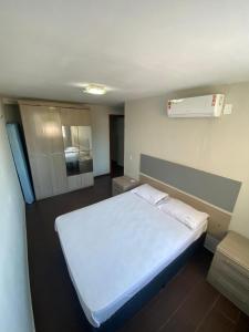 a bedroom with a white bed in a room at Flat 152 e 134 Amarracao shopping luis correia-PIAUI in Luis Correia