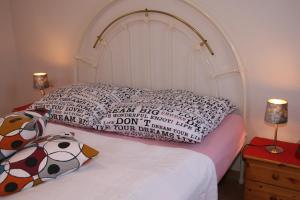 a white bed with a pillow and a stuffed animal on it at Ferienhaus "Kleiner Schoner" in Rerik
