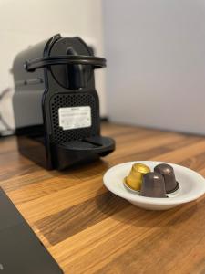 Eine Kaffeemaschine mit einem Teller voller Goldmünzen auf einer Theke in der Unterkunft Luxury apartment Bella Málaga in Málaga + 5 Fotos