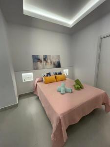 ein Schlafzimmer mit einem rosa Bett mit zwei Handtüchern darauf in der Unterkunft Luxury apartment Bella Málaga in Málaga