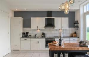 a kitchen with white cabinets and a wooden counter top at Lovely Home In Ovezande With Sauna in Ovezande