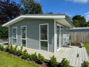 a tiny house with a deck in a yard at Main Street Retreat in Greytown