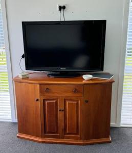 a flat screen tv sitting on top of a wooden cabinet at Main Street Retreat in Greytown +6 photos