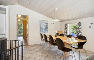 a dining room with a wooden table and chairs at Holiday Home Hagevej Ulfborg X in Ulfborg