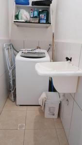 a small bathroom with a sink and a toilet at Apartamento Luz da Armação in Penha