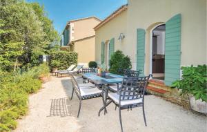 a patio with a table and chairs in front of a house at Amazing Home In Saint Remy De Provence in Saint-Rémy-de-Provence