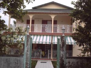 a house with a balcony and a porch at Appartement à 15min de belles plages in Sainte-Rose +5 photos