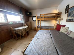 a bedroom with a bunk bed and a table at Résidence Le Pelvoux I - RESIDENCE LE PELVOUX I MAE-0031 in Vars