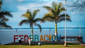 a group of people standing in front of a sign on the water at Dpto LUDIM 1 in Federación