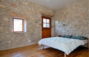 Montclusにある3 Bedroom Gorgeous Home In Montclusの石壁のベッドルーム(ベッド付)