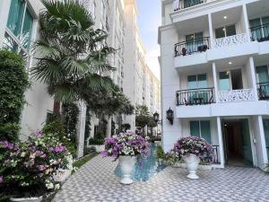 un edificio con dos jarrones blancos llenos de flores en Free Power&WiFi,Work Remotely, Kitchen,Deal, en Pattaya South