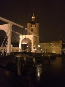 a large building with a clock tower at night at De Oude Haven in Zierikzee
