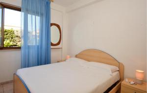 ein Schlafzimmer mit einem Bett mit blauem Vorhang und einem Fenster in der Unterkunft 3 Bedroom Nice Home In Marina Di Modica in Marina di Modica