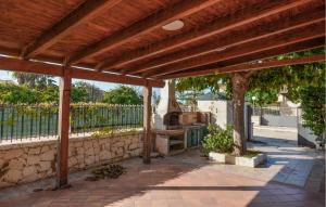 eine hölzerne Pergola mit einer Steinmauer in der Unterkunft 3 Bedroom Nice Home In Marina Di Modica in Marina di Modica