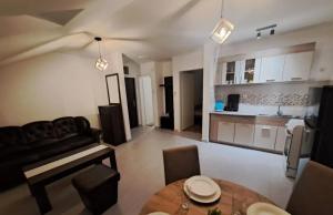 a living room with a table and a kitchen at Apartman Una Banja Vrujci in Mionica