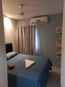 a bedroom with a blue bed and a fan at Casa em condomínio in Cuiabá