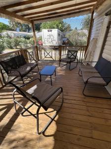 four chairs and a table on a wooden deck at Camping Del Mar B10, Mobile Home Excellence, 3 chambres, 6 personnes, bord de mer in Argelès-sur-Mer