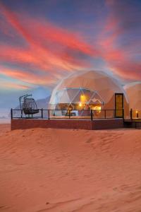 a domed tent in the desert with a sunset at Ayman camp in Wadi Rum