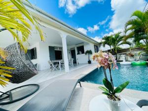 a villa with a swimming pool and a house at Villas TROPICAL & EXOTIC, 6 chambres avec 2 piscines in Le Moule