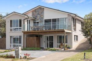 a large white house with a balcony at Waterfront and direct beach access with views in Ulladulla