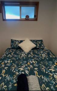 a bedroom with a bed with a pillow and a window at Waterfront and direct beach access with views in Ulladulla