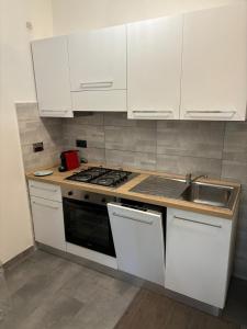 托瓦尼亚Brezza Marina - Appartamento moderno vista mare的厨房配有白色橱柜、炉灶和水槽。