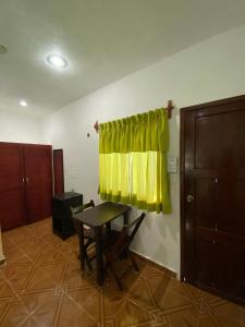 a room with a table and a yellow curtain at Casa Victor Avila in Holbox Island +51 photos