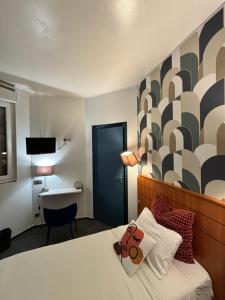 a bedroom with a bed with a teddy bear on it at Hôtel Astrid in Rouen