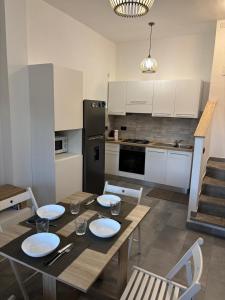 托瓦尼亚Brezza Marina - Appartamento moderno vista mare的一间带餐桌的厨房和一间带白色橱柜的厨房