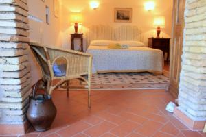 ein Schlafzimmer mit einem Bett und einem Stuhl in einem Zimmer in der Unterkunft B&B Colle Perrini Country House in Casperia