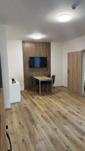 an office with a table and chairs and a television at Apartment Urban Oasis in Olomouc