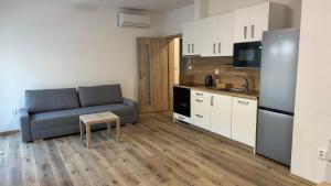 a living room with a couch and a kitchen at Apartment Urban Oasis in Olomouc