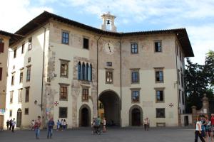 a large building with a clock on the side of it at Hotel Milano in Pisa