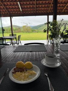 a plate of food on a table with a cup of coffee at Pousada Arraial da Canastra na Serra da Canastra in Vargem Bonita