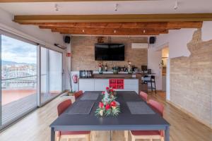 a kitchen and living room with a table with flowers on it at Àtic la Llotja in Tortosa
