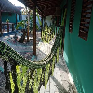 un hamac suspendu à un bâtiment situé à côté d'un bâtiment dans l'établissement Hawaii Flats, à São Miguel do Gostoso