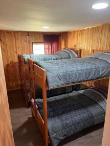 Dos literas en una habitación con paredes de madera. en Cabañas Don Agustín Pucón, en Pucón 46 fotos más