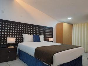 una camera da letto con un letto grande con cuscini blu di Largo da Fonte a Sertã Altre 35 foto