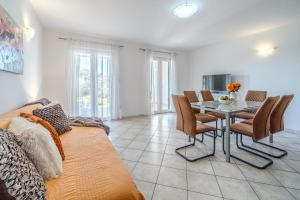 a living room with a couch and a table and chairs at Apartment Milna - with Swimming Pool & Amazing Seaviews, above Bijaka Beach in Milna