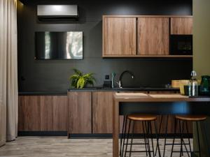 Una cocina con gabinetes de madera y un mostrador con taburetes. en Osada Pod Łąkami, en Rudka Bałtowska