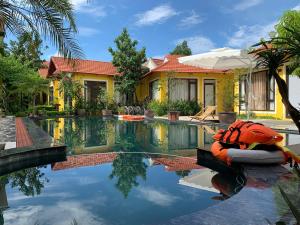 a house with a swimming pool in front of a house at Azalea Tam Coc Ninh Bình in Ninh Binh